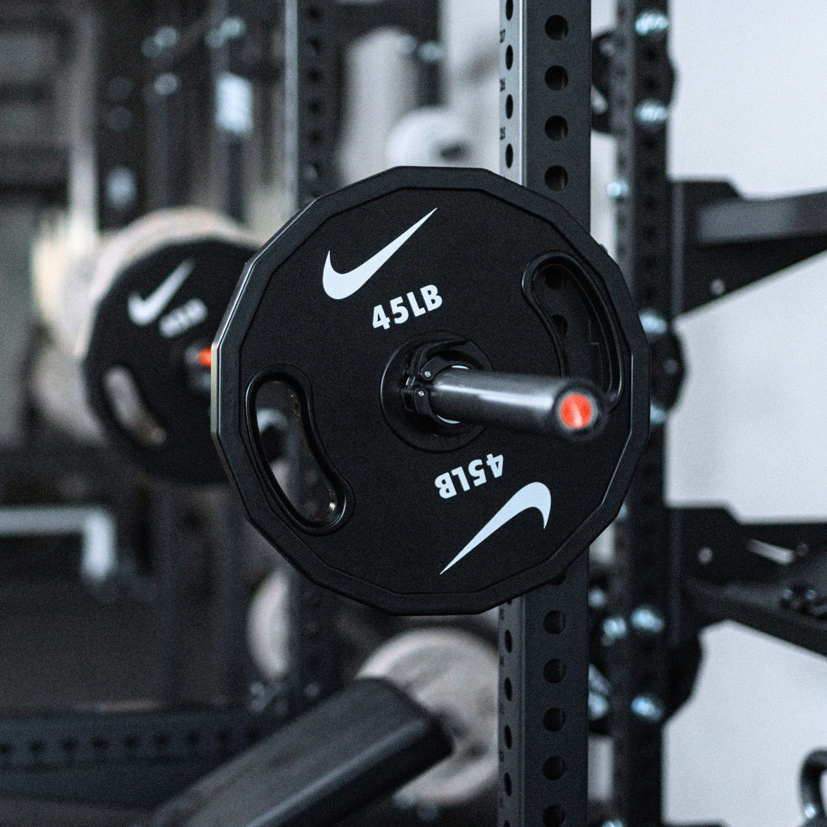 Nike Strength weight plate close-up showing premium construction, grip design, and weight marking details.